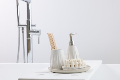 Photo of Different personal care products and accessories on bath tub in bathroom