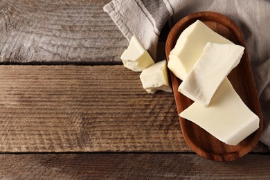 Photo of Pieces of tasty white chocolate on wooden table, top view. Space for text