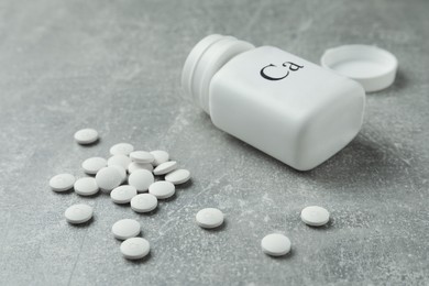 Photo of Calcium supplement pills and bottle on grey table