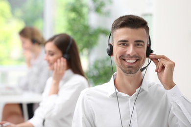 Young male receptionist with headset in office