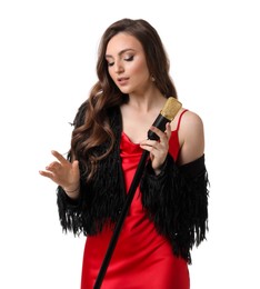 Beautiful young woman in stylish red dress with microphone singing on white background