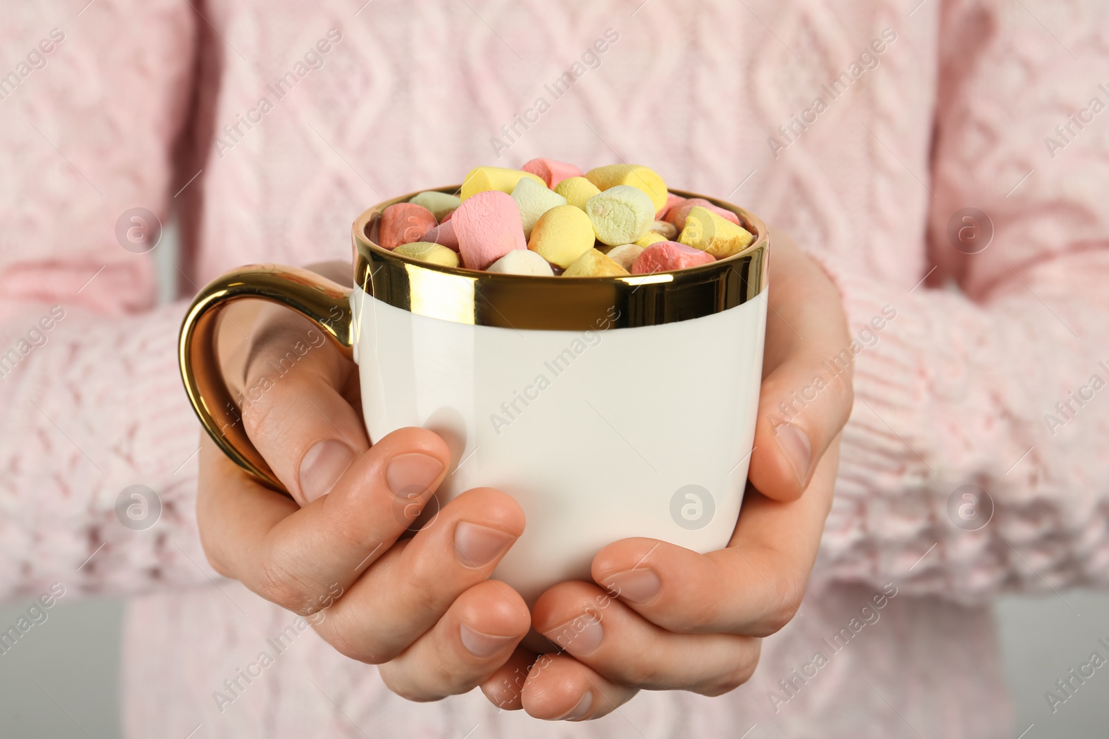 Photo of Woman holding cup of delicious hot chocolate with marshmallows, closeup