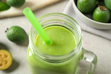 Photo of Fresh feijoa smoothie in mason jar on light table, closeup