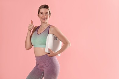 Photo of Beautiful woman with scales showing thumbs up on pink background, space for text