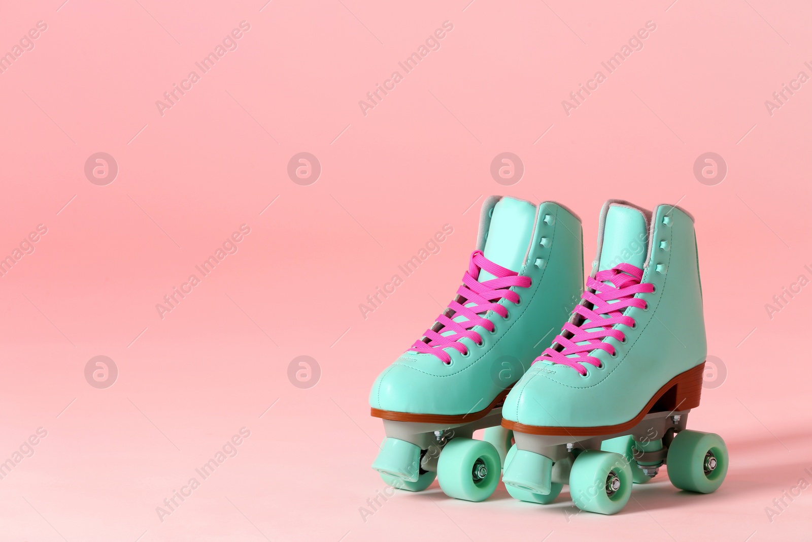 Photo of Pair of vintage roller skates on color background. Space for text