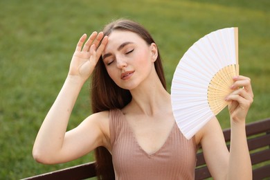 Photo of Woman with hand fan suffering from heat outdoors