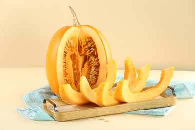 Photo of Cut fresh ripe pumpkin on beige background