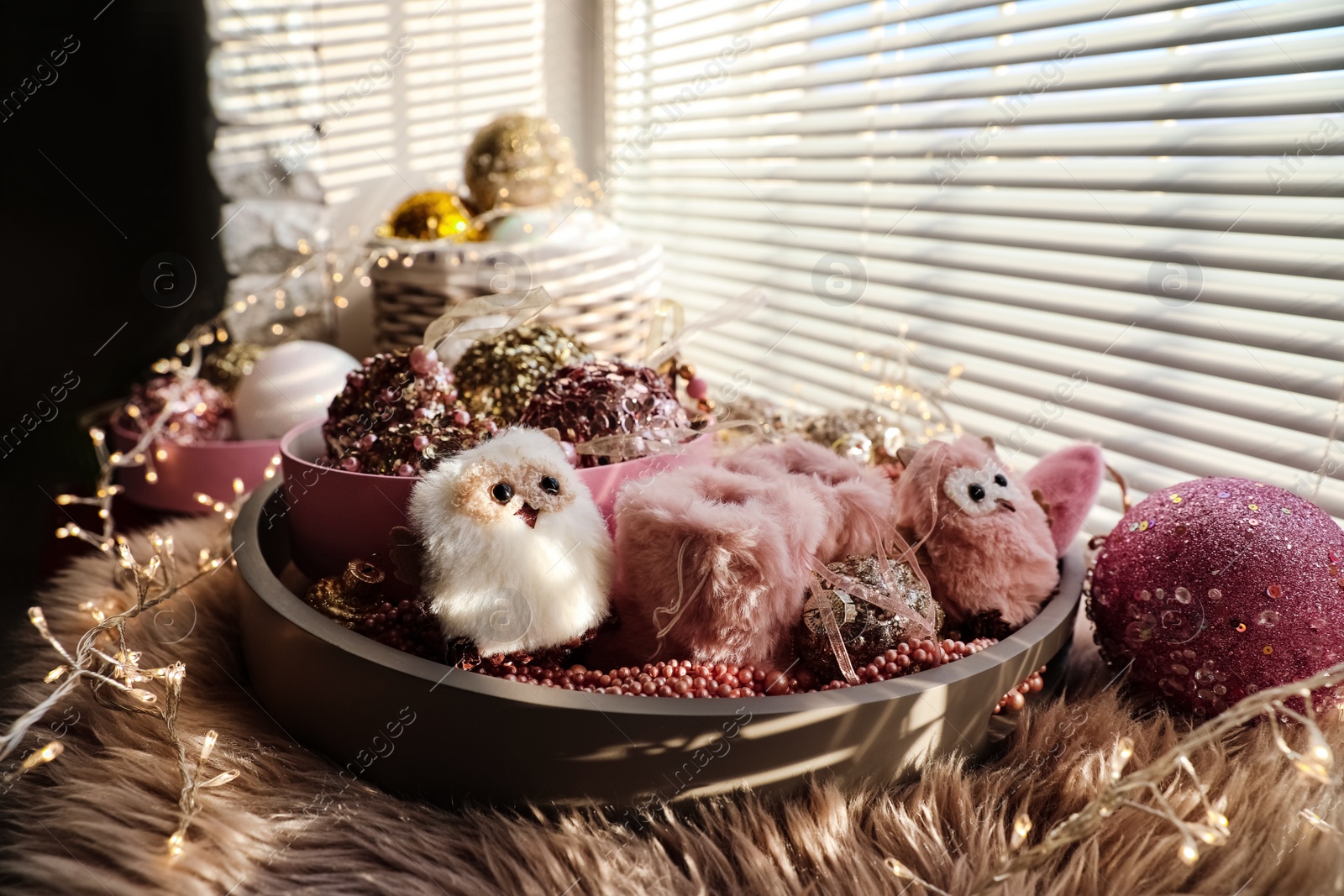 Photo of Beautiful Christmas tree baubles, toys and fairy lights on window sill indoors