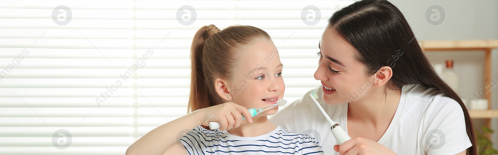 Image of Mother and her daughter brushing teeth together in bathroom. Banner design with space for text