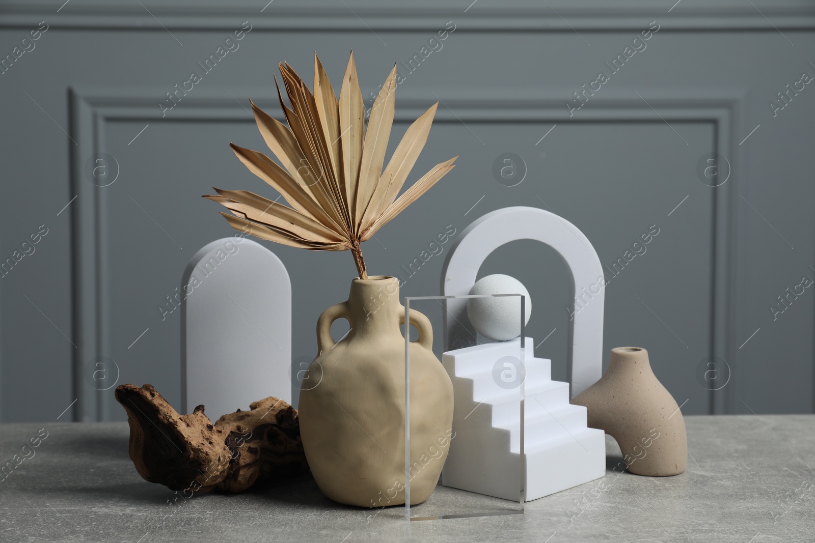 Photo of Clay flagon with other decorative elements on grey textured table