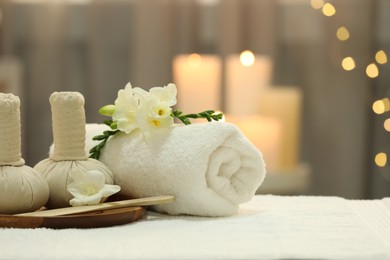 Photo of Beautiful composition with different spa products and flowers on white towel against blurred background. Space for text