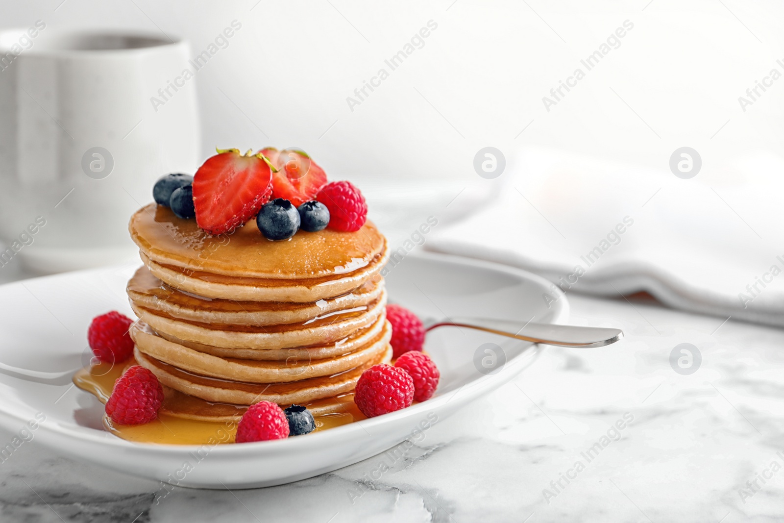 Photo of Tasty pancakes with berries and honey on plate