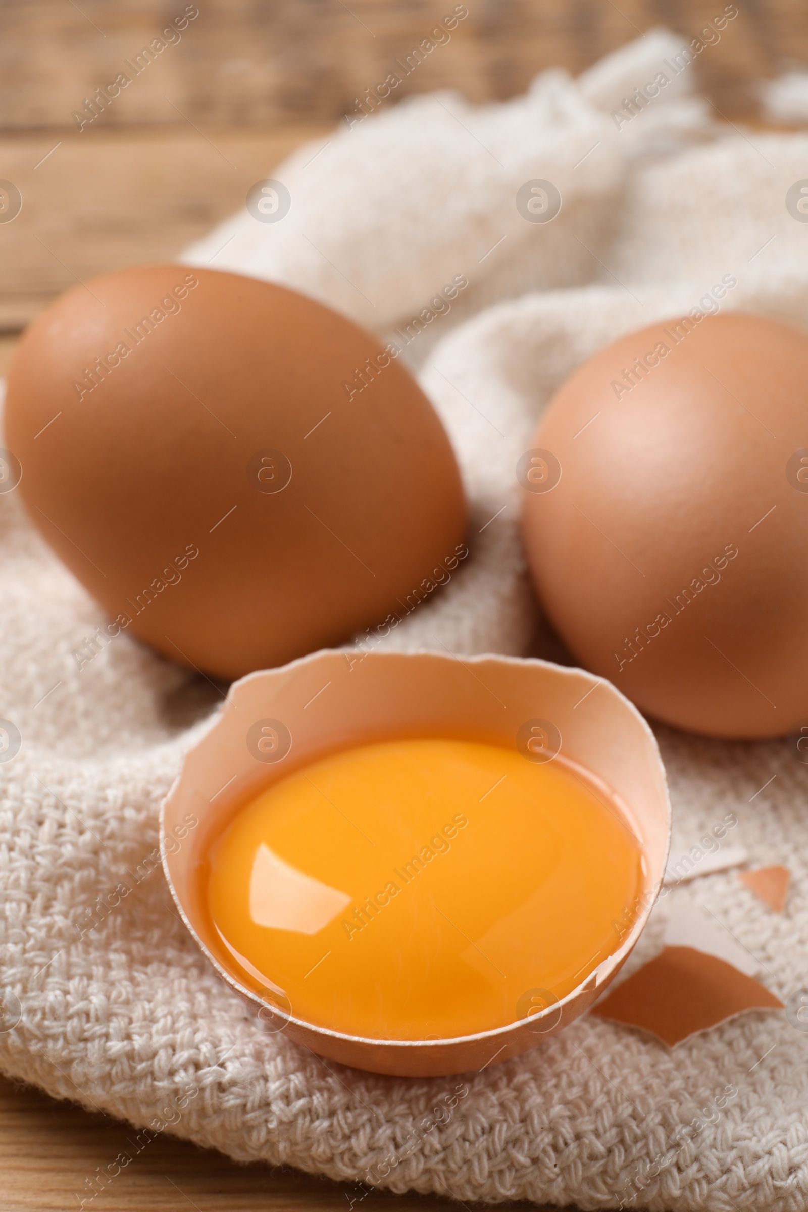 Photo of Whole and cracked eggs on table, closeup