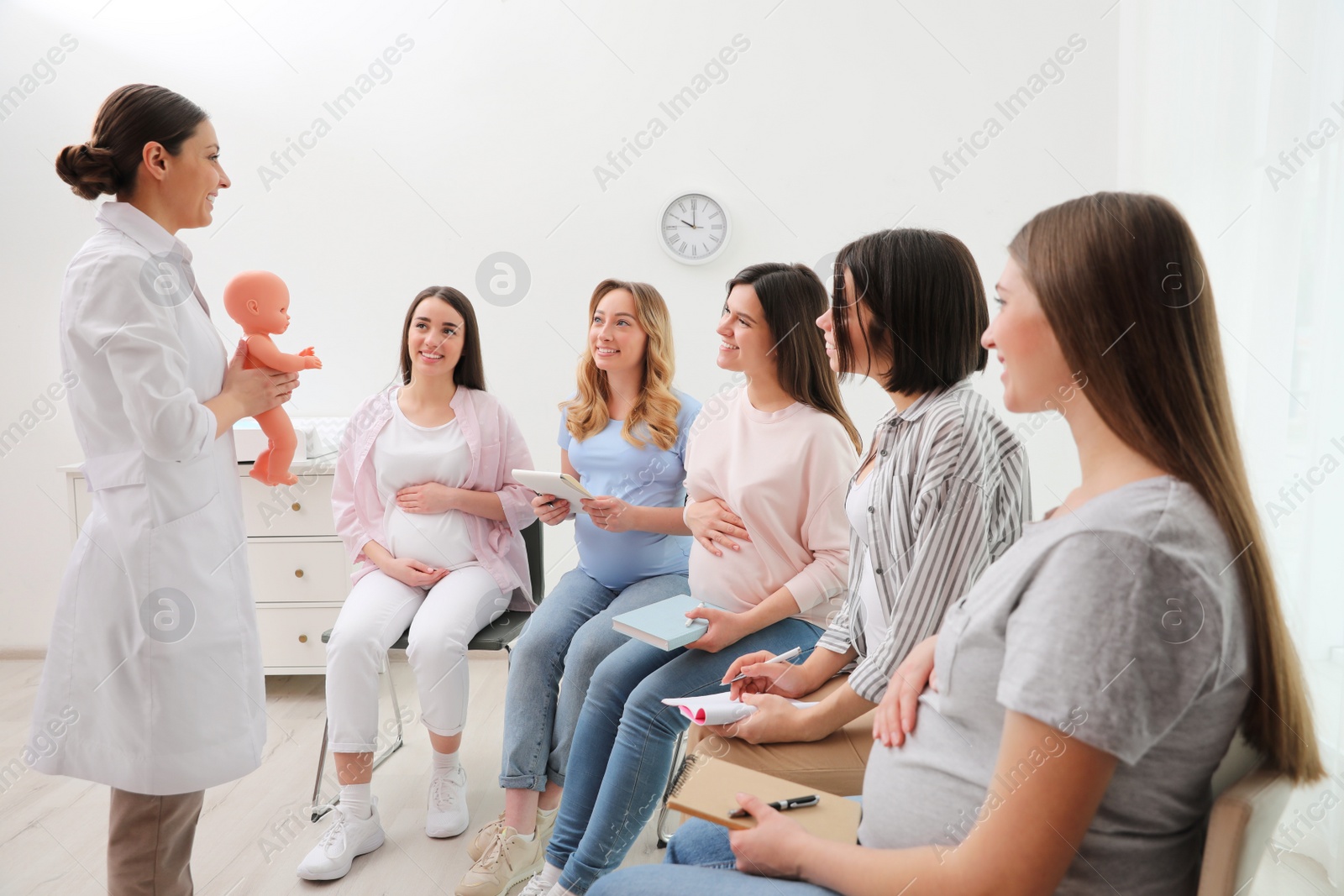 Photo of Group of pregnant women with doctor at courses for expectant mothers indoors