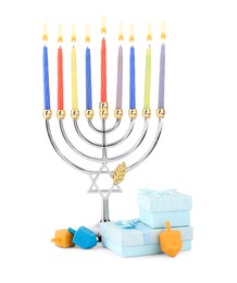 Photo of Hanukkah celebration. Menorah with candles, gift boxes and colorful dreidels isolated on white
