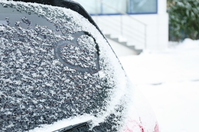 Heart drawn on car covered with snow outdoors. Space for text