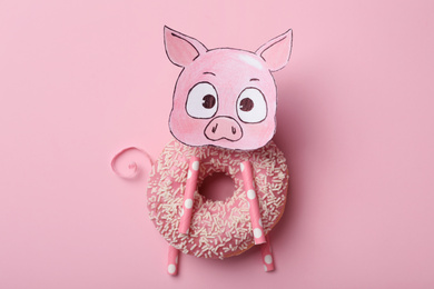 Photo of Funny pig made with donut and piece of paper on pink background, top view