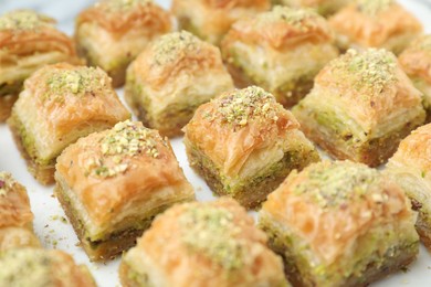 Photo of Delicious fresh baklava with chopped nuts on white table, closeup. Eastern sweets
