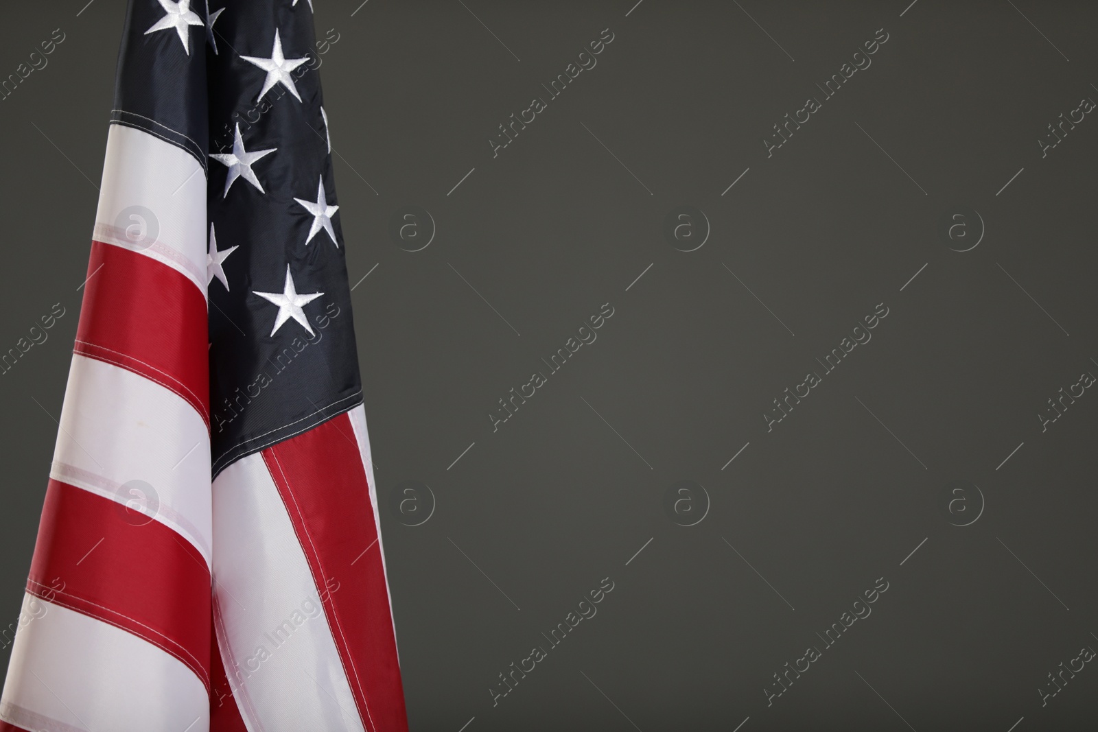 Photo of USA flag on grey background. Space for text