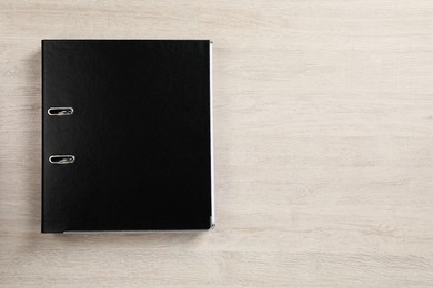 Photo of Black office folder on white wooden table, top view. Space for text