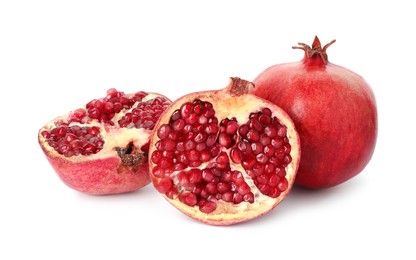 Photo of Halves and whole pomegranates isolated on white