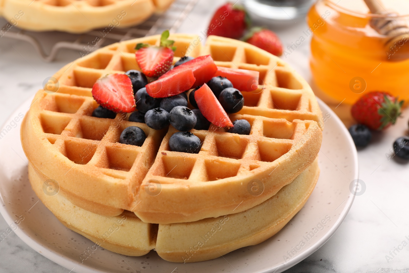 Photo of Tasty Belgian waffles with fresh berries on table, closeup