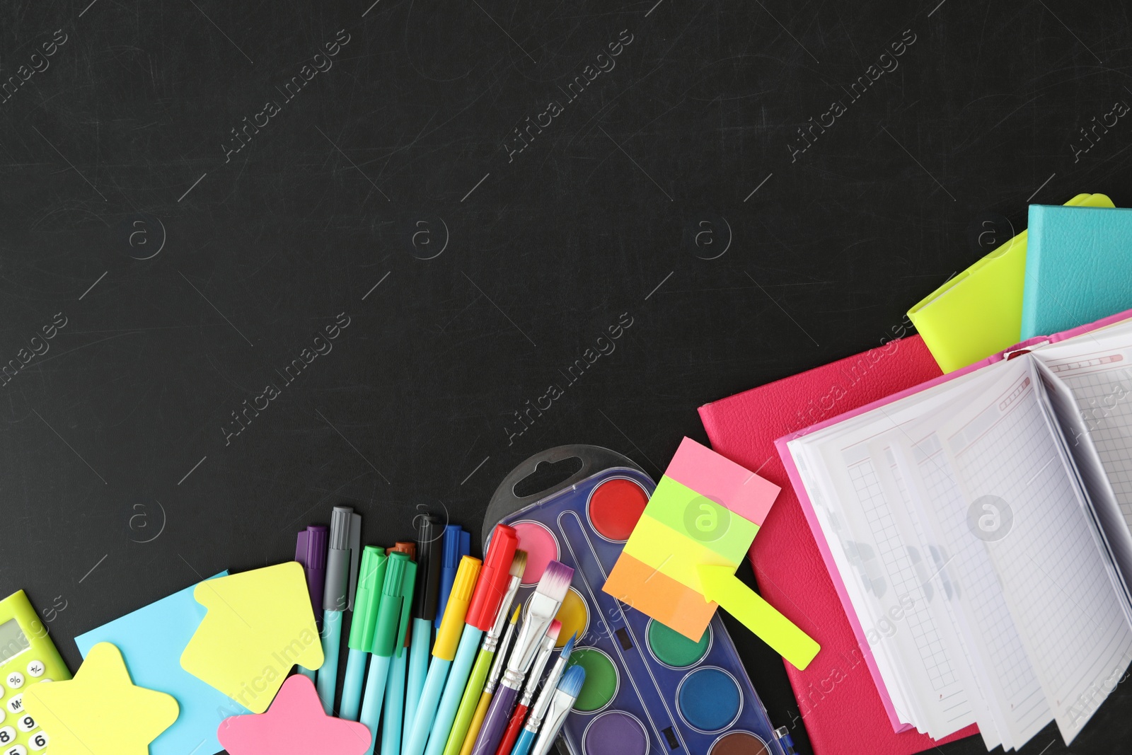 Photo of Flat lay composition with different school stationery on blackboard, space for text. Back to school