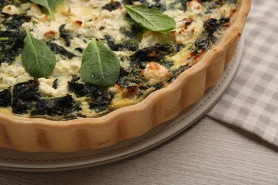 Delicious homemade spinach quiche on table, closeup
