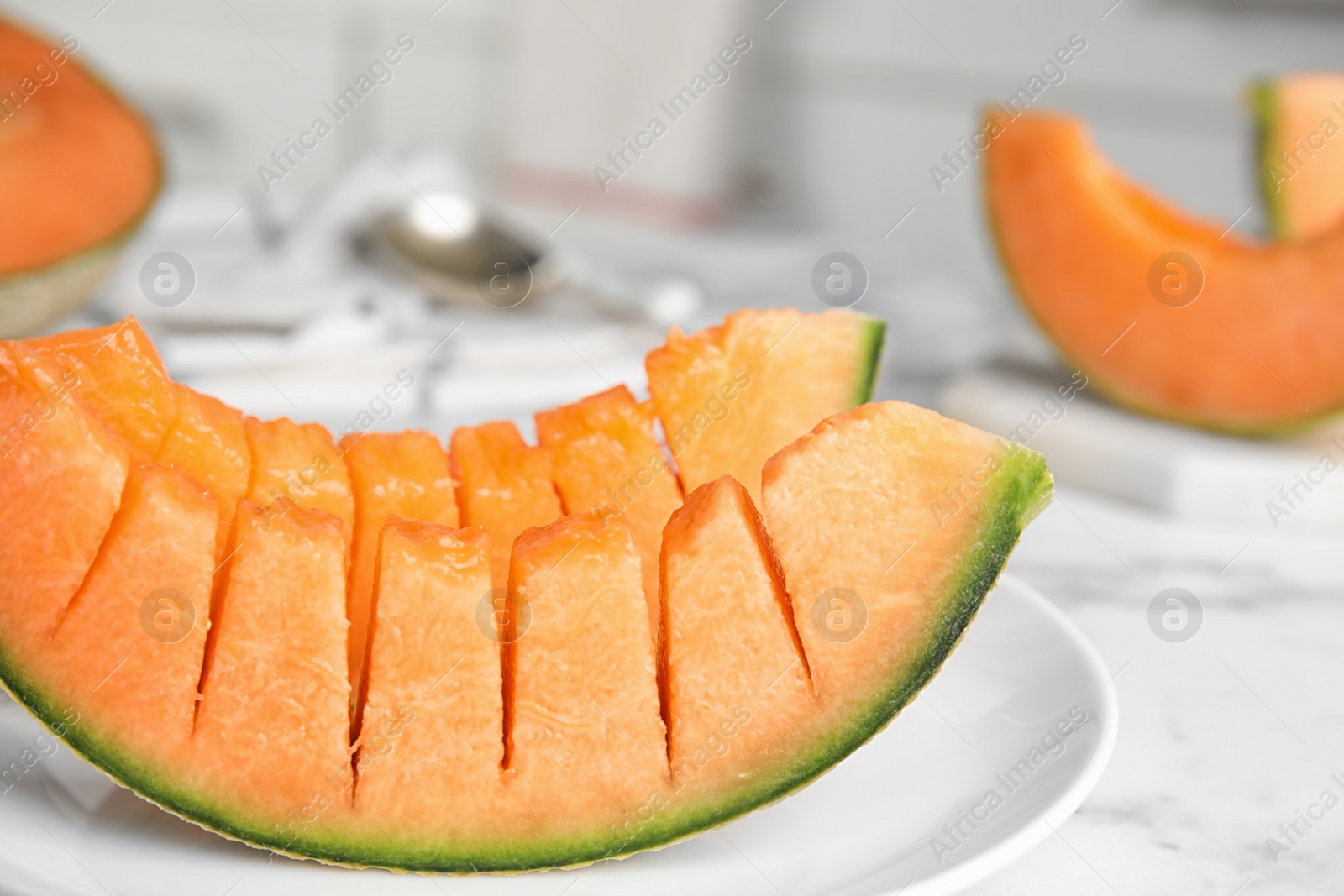 Photo of Slices of ripe cantaloupe melon on marble table, closeup