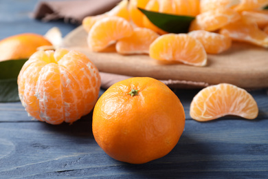 Fresh ripe tangerines on blue wooden table, closeup