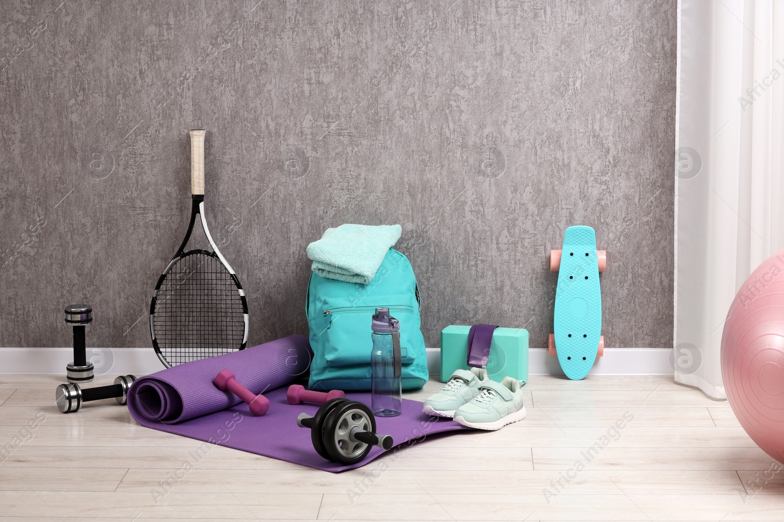 Photo of Many different sports equipment near grey wall indoors