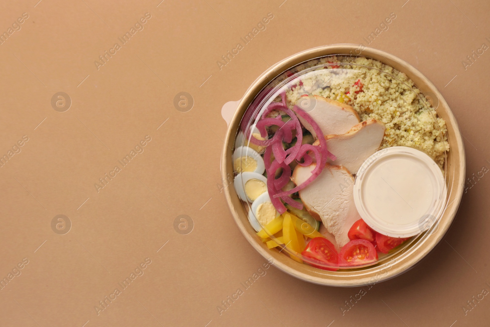 Photo of Tasty food in container on beige background, top view. Space for text