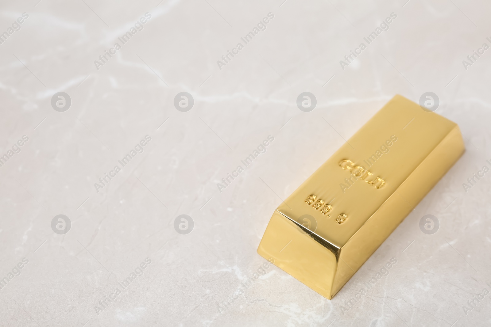 Photo of Shiny gold bar on table. Space for text