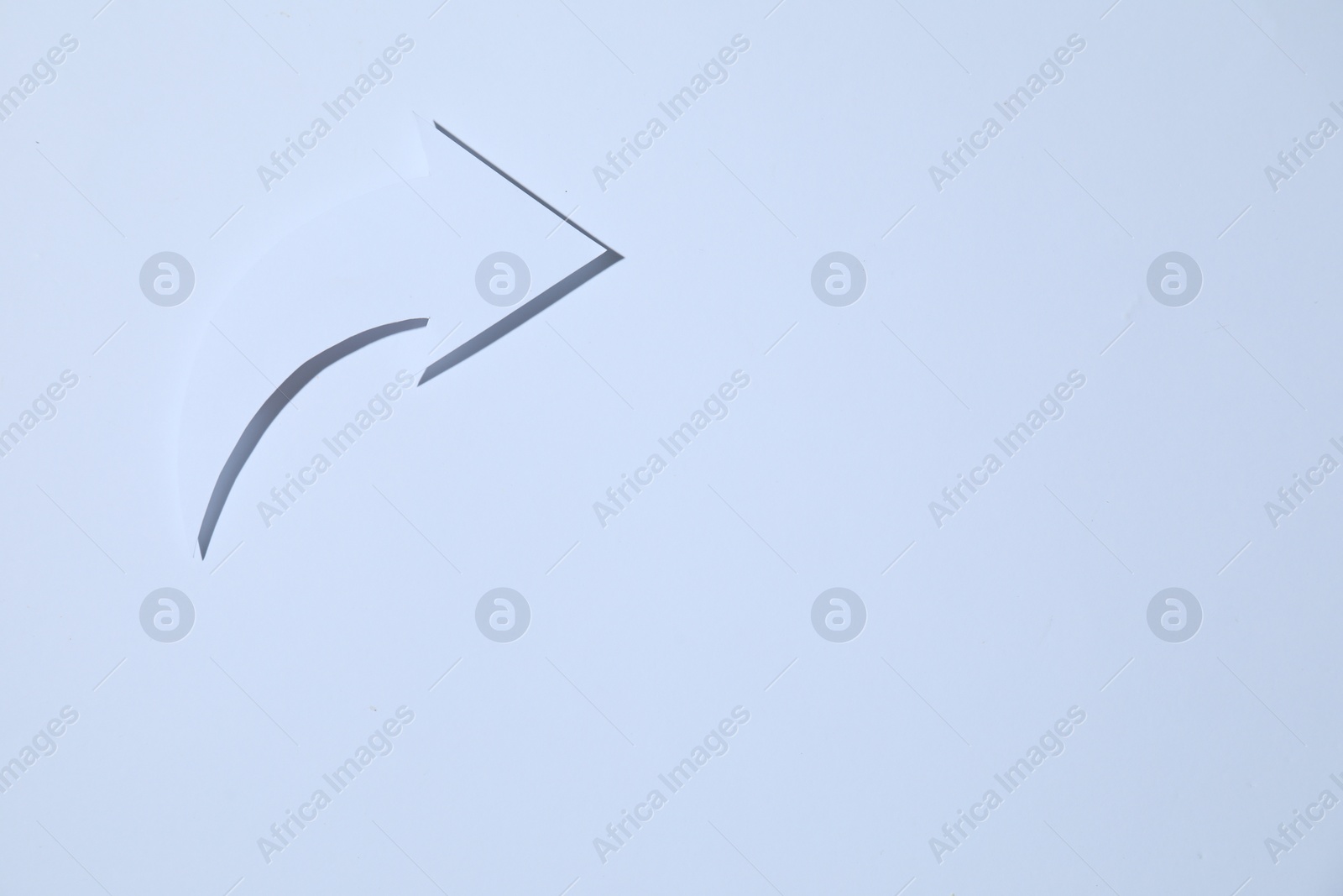 Photo of Curved paper arrow on white background, top view. Space for text