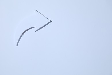 Curved paper arrow on white background, top view. Space for text