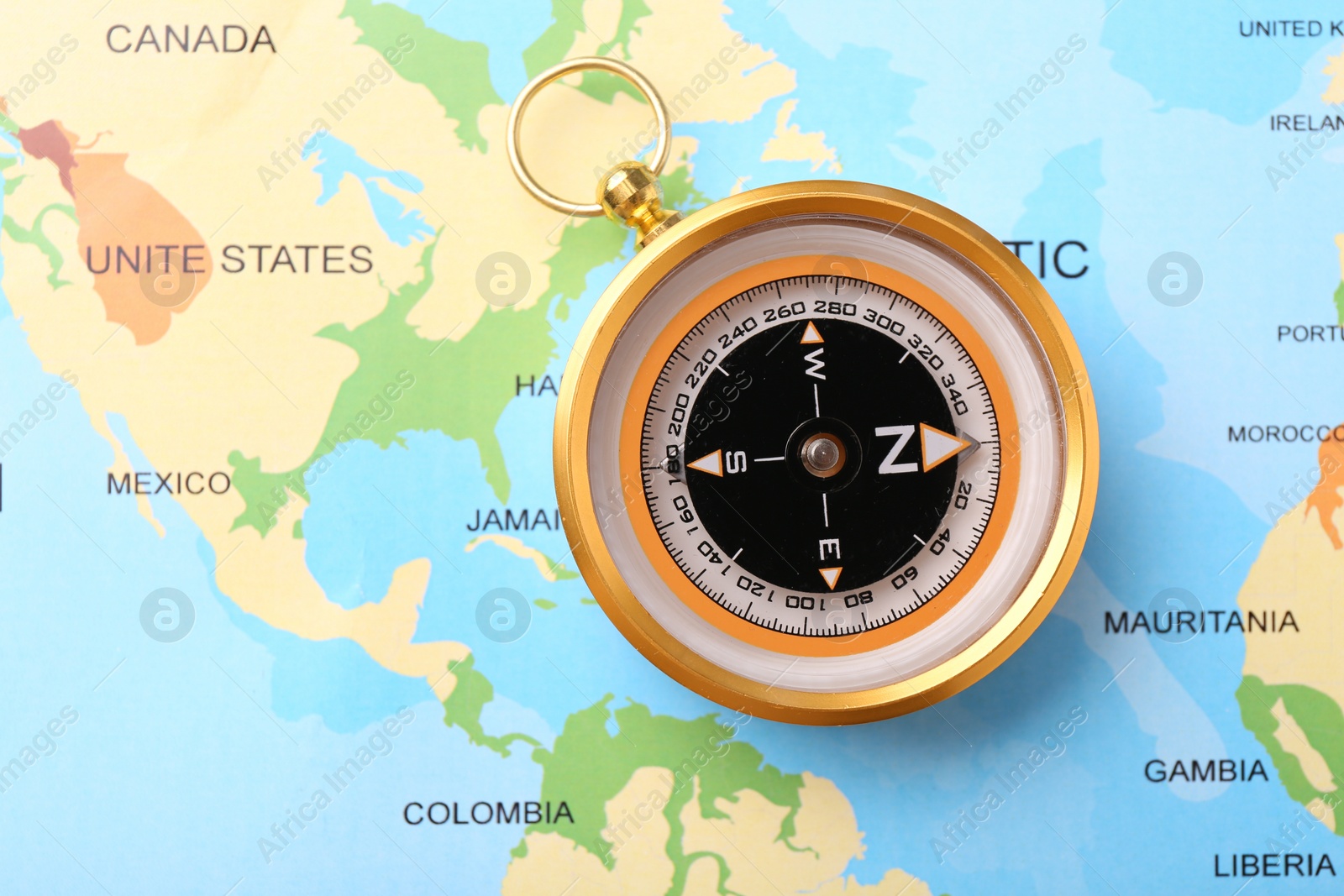 Photo of Compass on world map, top view. Navigation equipment