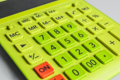 Photo of Closeup view of green calculator on light background