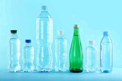 Set of different plastic bottles with pure water on color background