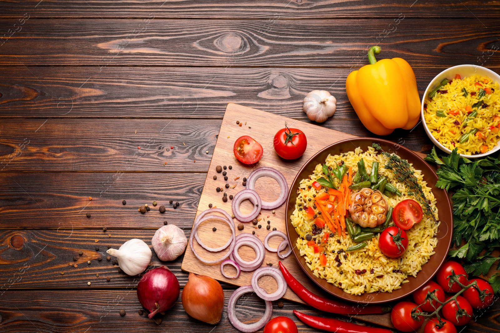 Photo of Flat lay composition with tasty rice pilaf on wooden table. Space for text