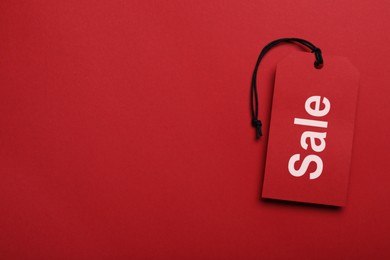 Tag and space for text on red background, top view. Black Friday sale