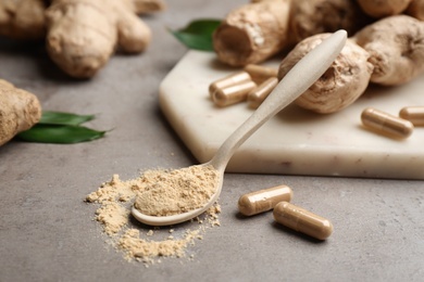 Photo of Dry, capsuled and fresh ginger on grey table