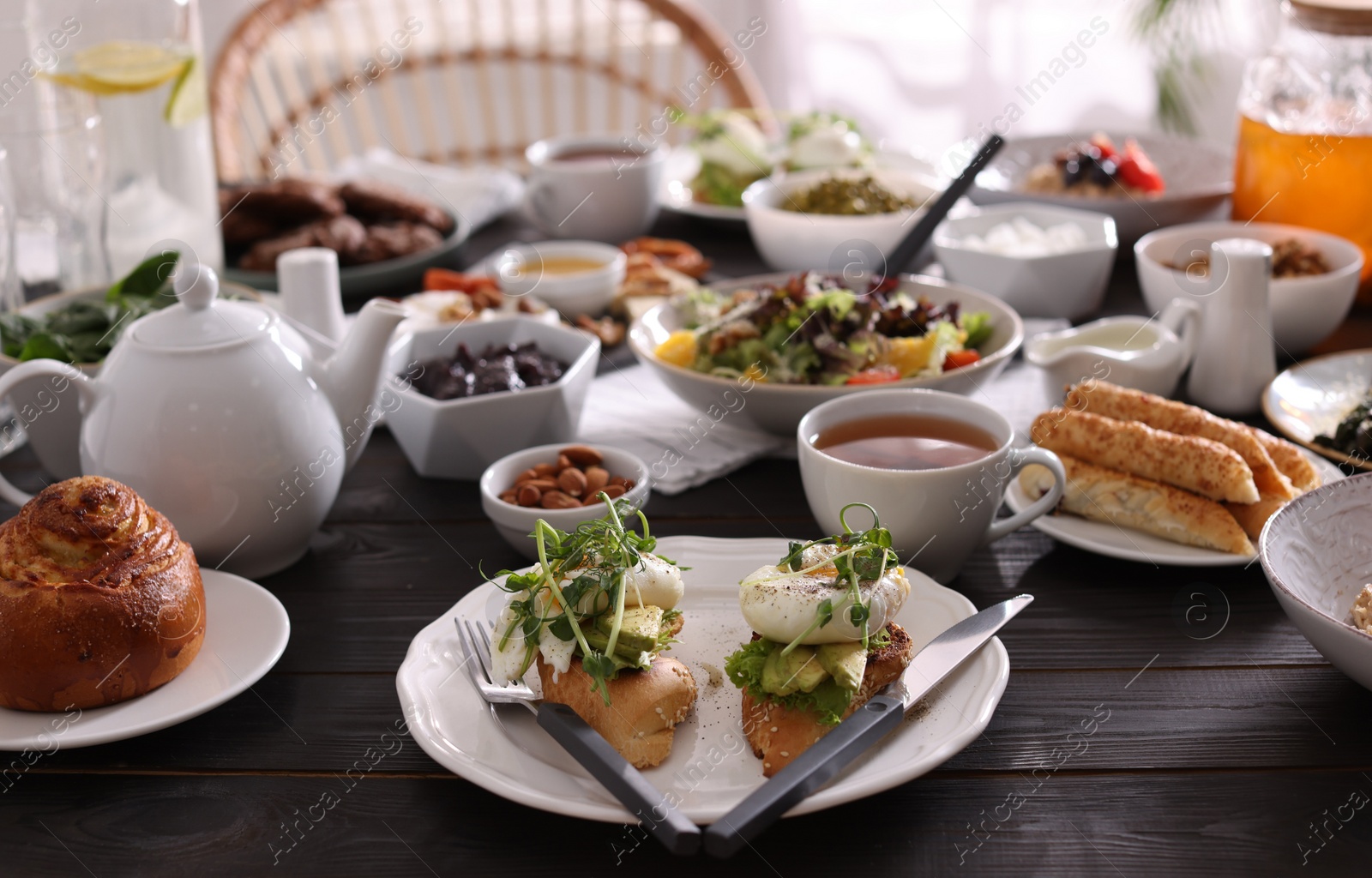 Photo of Delicious sandwiches and many different dishes served on buffet table for brunch