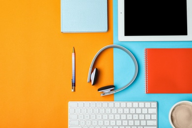 Flat lay composition with tablet, computer keyboard, headphones and space for text on color background