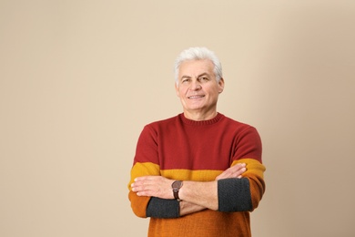 Portrait of handsome mature man on color background. Space for text