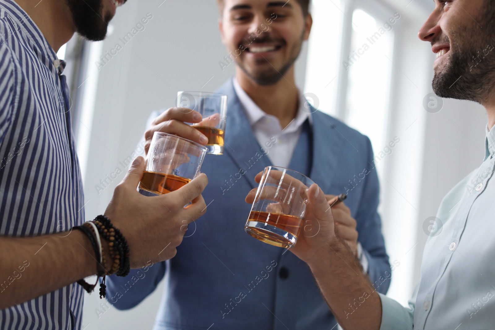 Photo of Group of friends drinking whiskey together indoors
