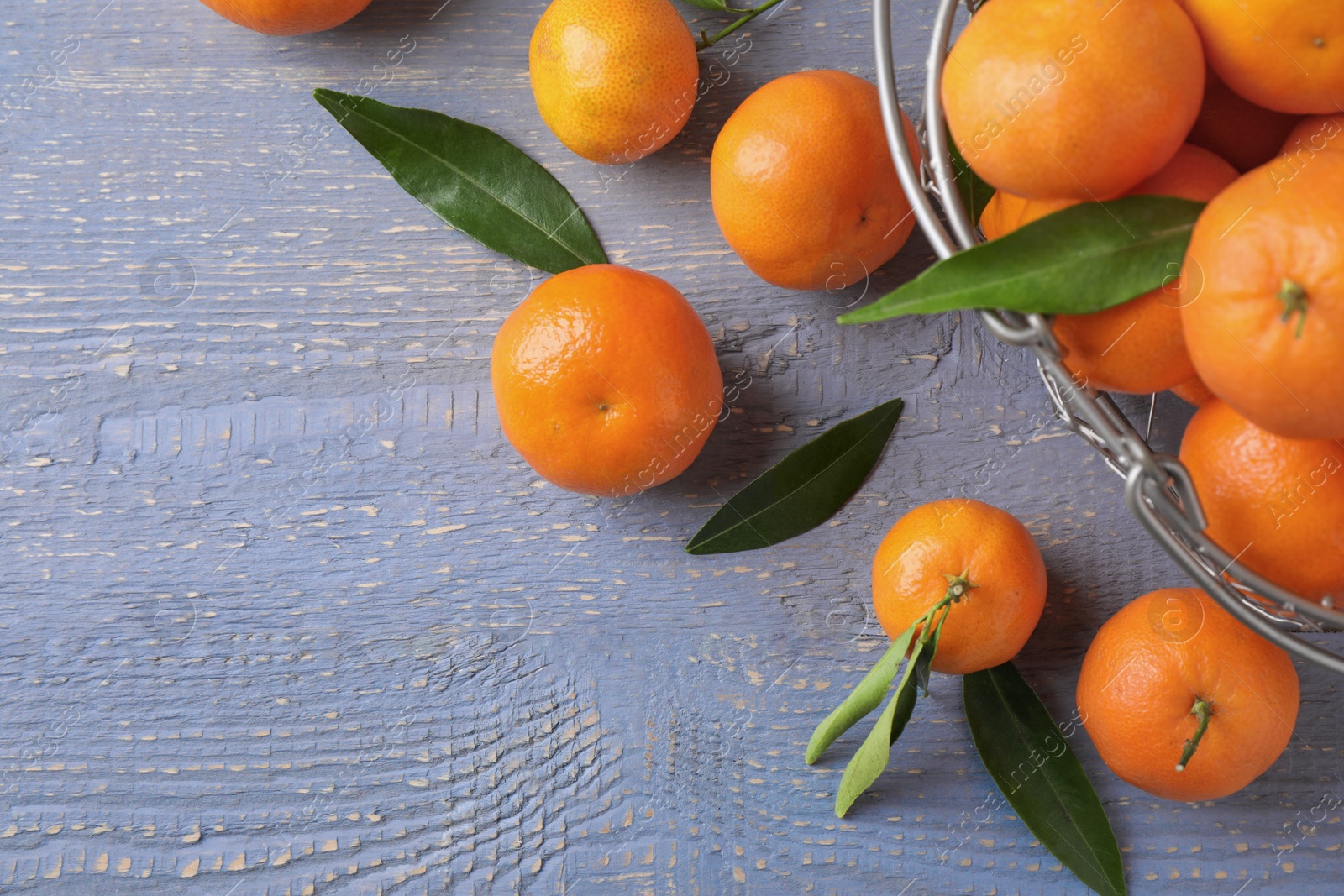 Photo of Fresh ripe tangerines on grey wooden table, flat lay. Space for text