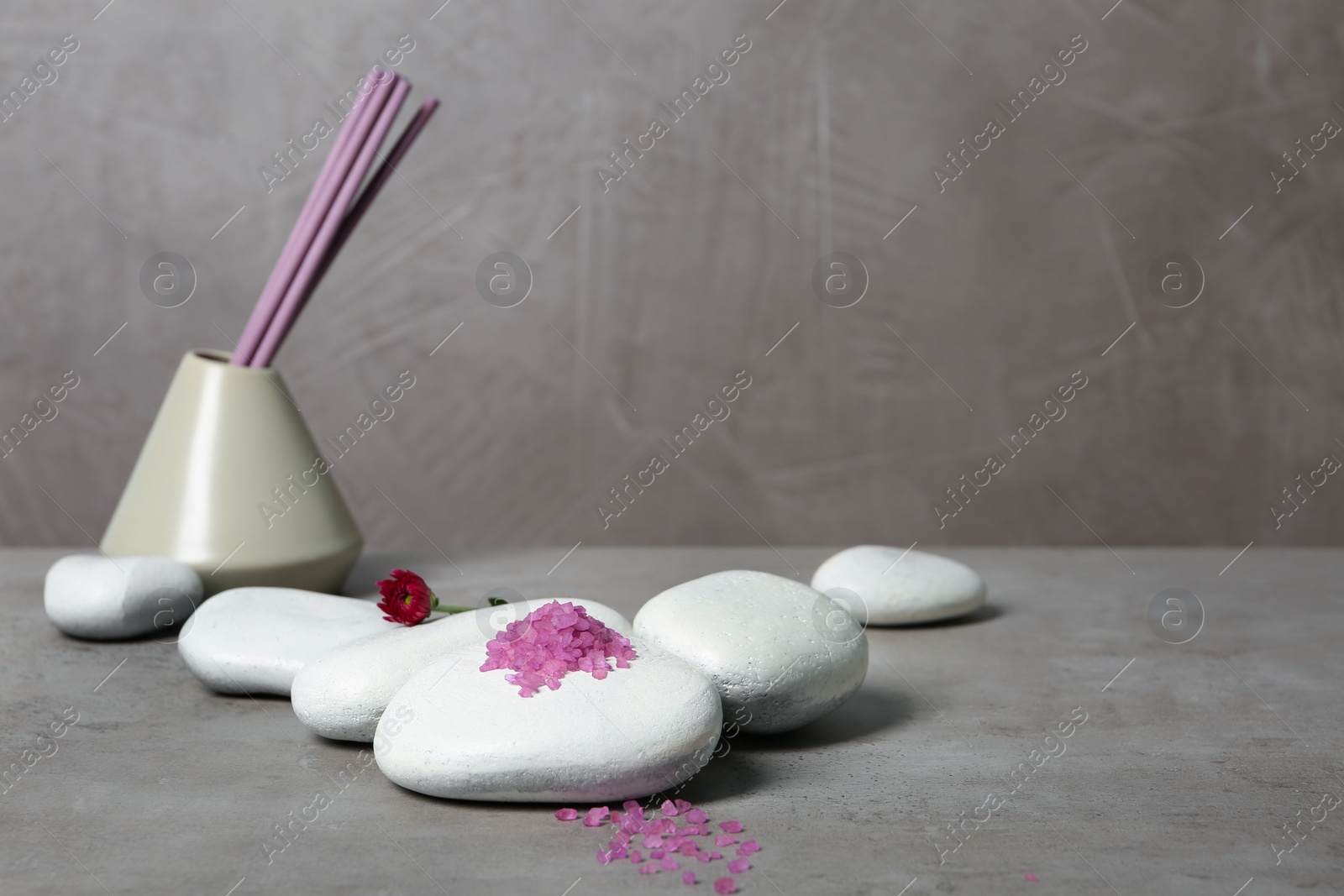 Photo of Beautiful composition with spa stones and bath salt on table. Space for text