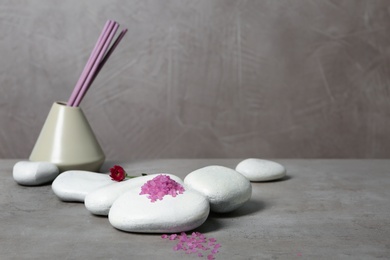 Photo of Beautiful composition with spa stones and bath salt on table. Space for text