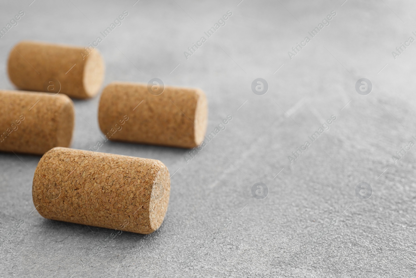 Photo of Wine bottle corks on light grey table, closeup. Space for text