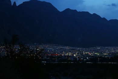 Photo of Picturesque view of beautiful city near mountains at night